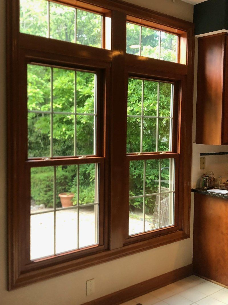 A kitchen with a lot of windows and a patio in the background.