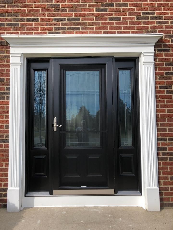 A brick building with a black door and white trim