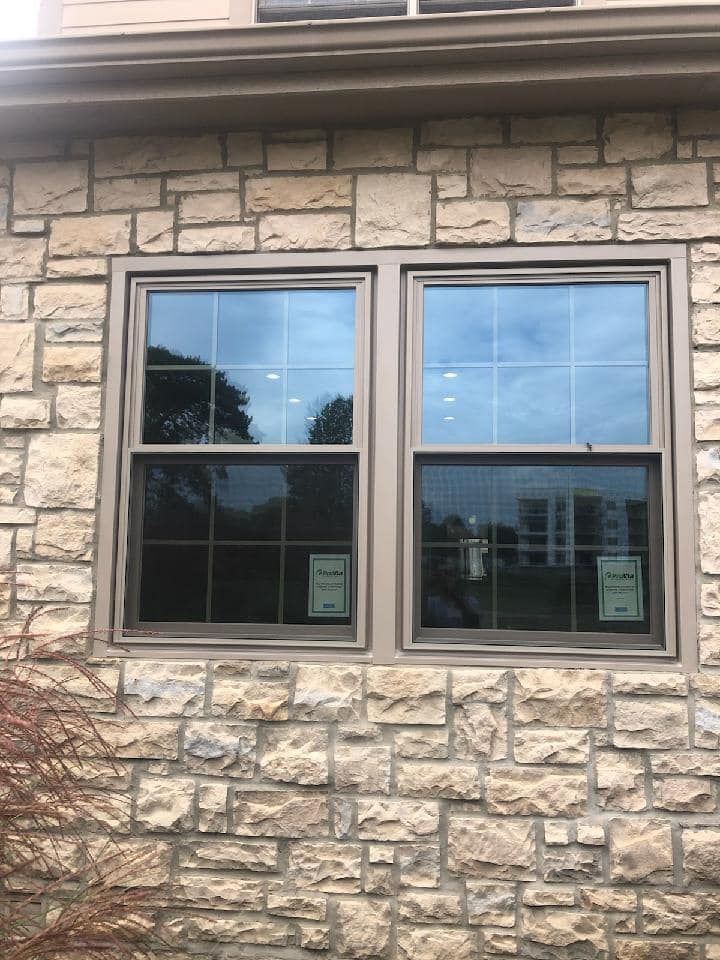 A brick building with two windows on the side of it