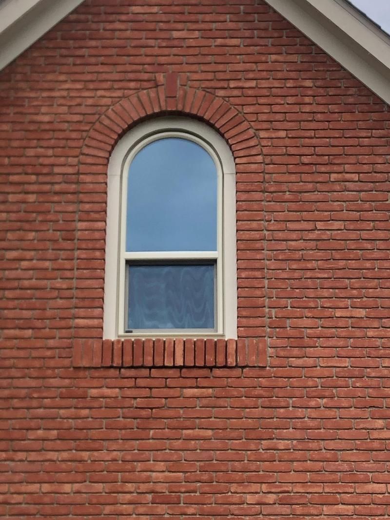 A red brick building with an arched window on the side.