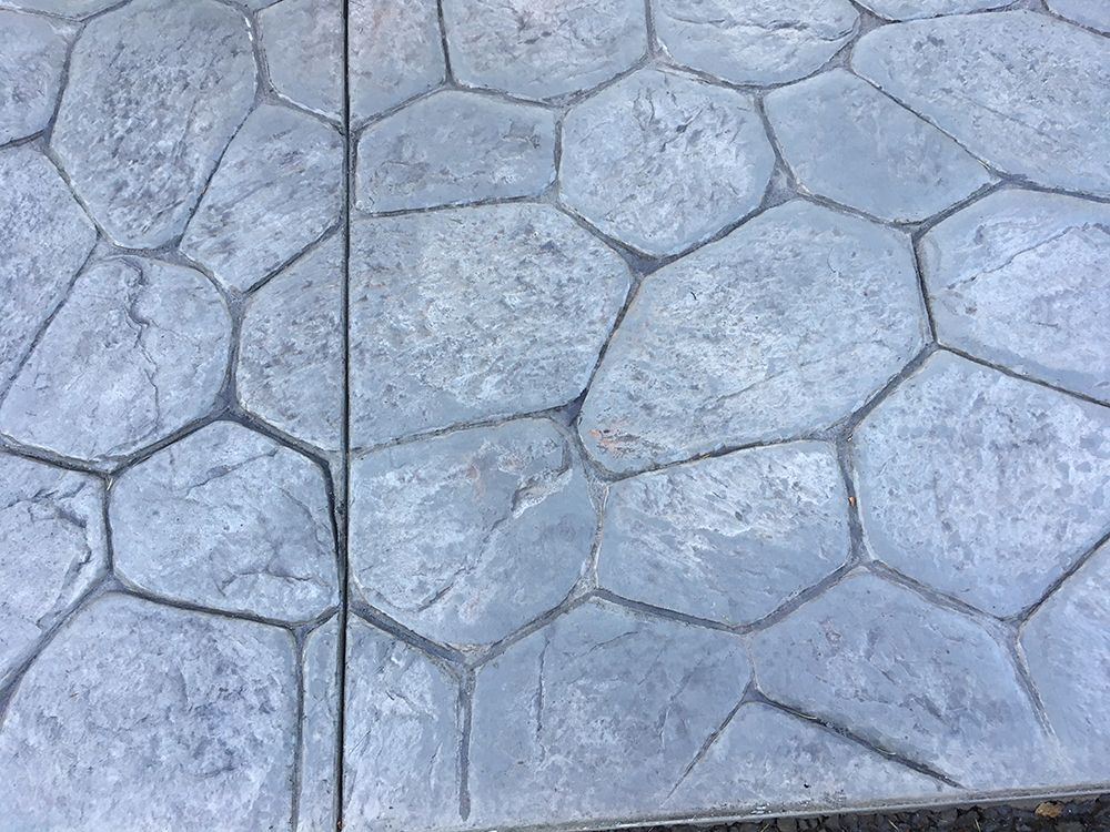 Grey stamped concrete patio with stone pattern.