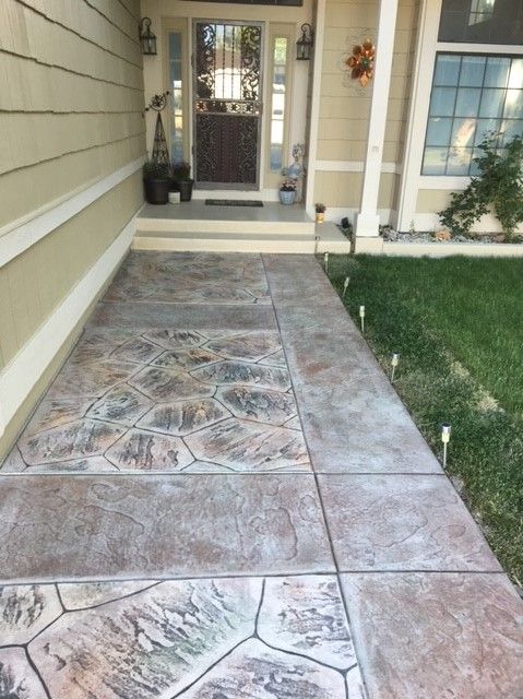 Concrete walkway with textured pattern leading to a house entrance.