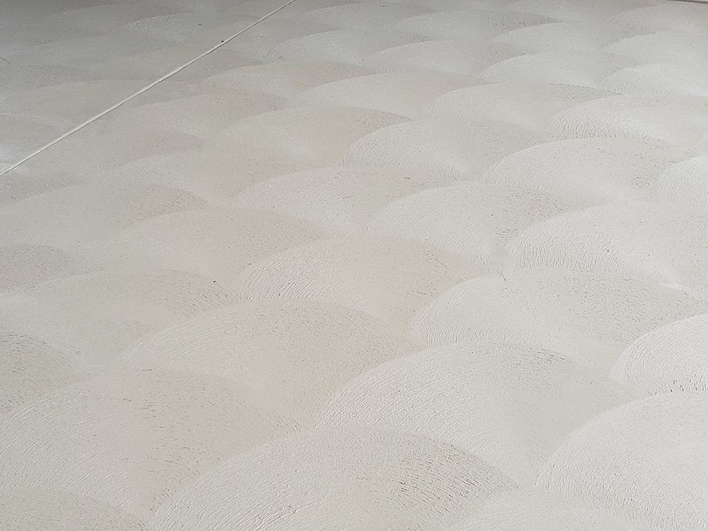 Light beige floor with repeating, semicircular texture pattern.