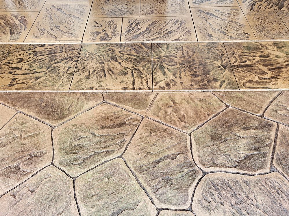 Stamped concrete flooring with varied textured patterns in brown and tan tones.
