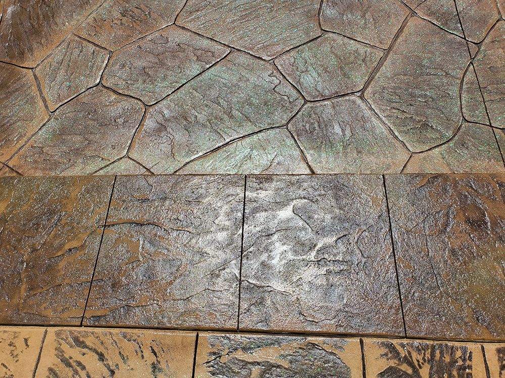 Close-up of three different concrete textures: large stone pattern, brick pattern, and a wood grain design. Brown and green hues.