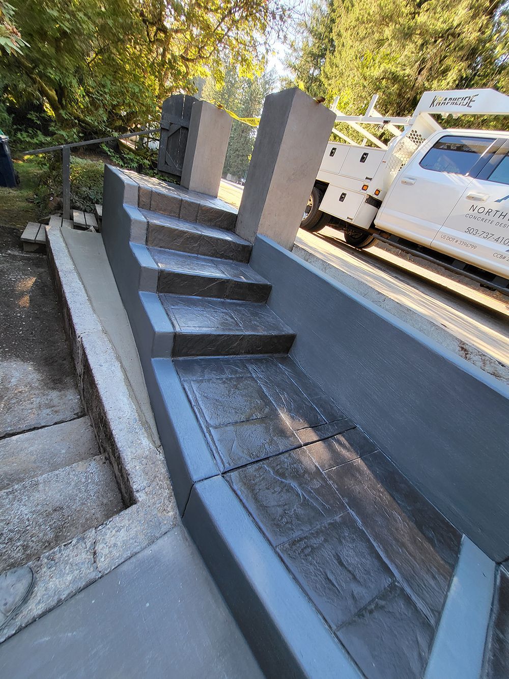Concrete stairs with gray walls and a truck parked beside them.