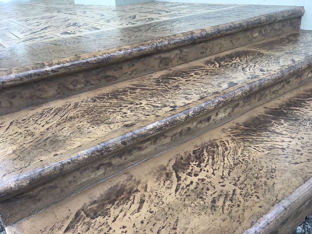Textured concrete steps, brown and tan hues, with weathered pattern.