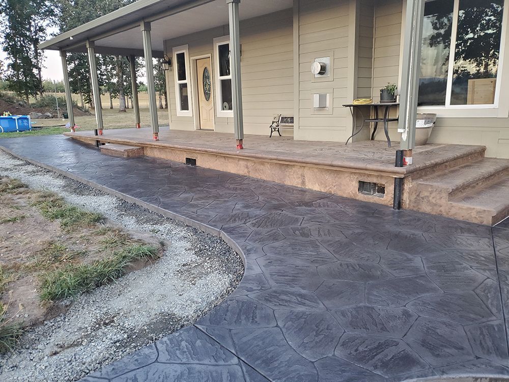 Gray stamped concrete pathway and porch of a house.