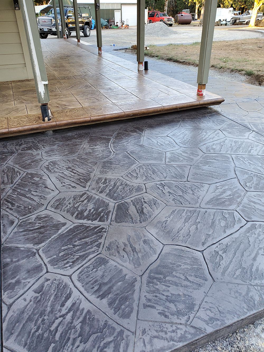 Stamped concrete patio with a dark grey stone pattern.