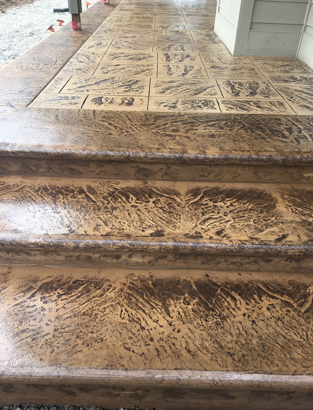 Stamped concrete porch and steps with textured, brown pattern.
