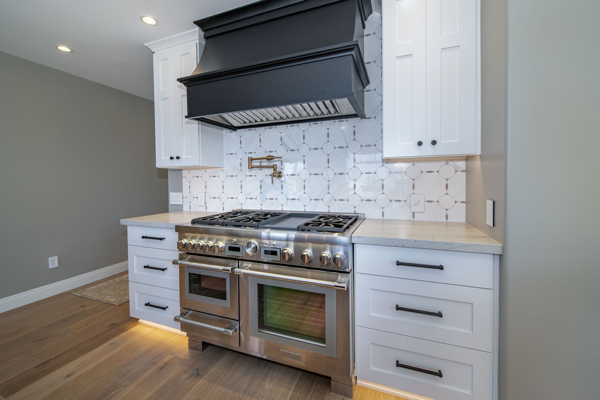 A kitchen with stainless steel appliances and white cabinets.