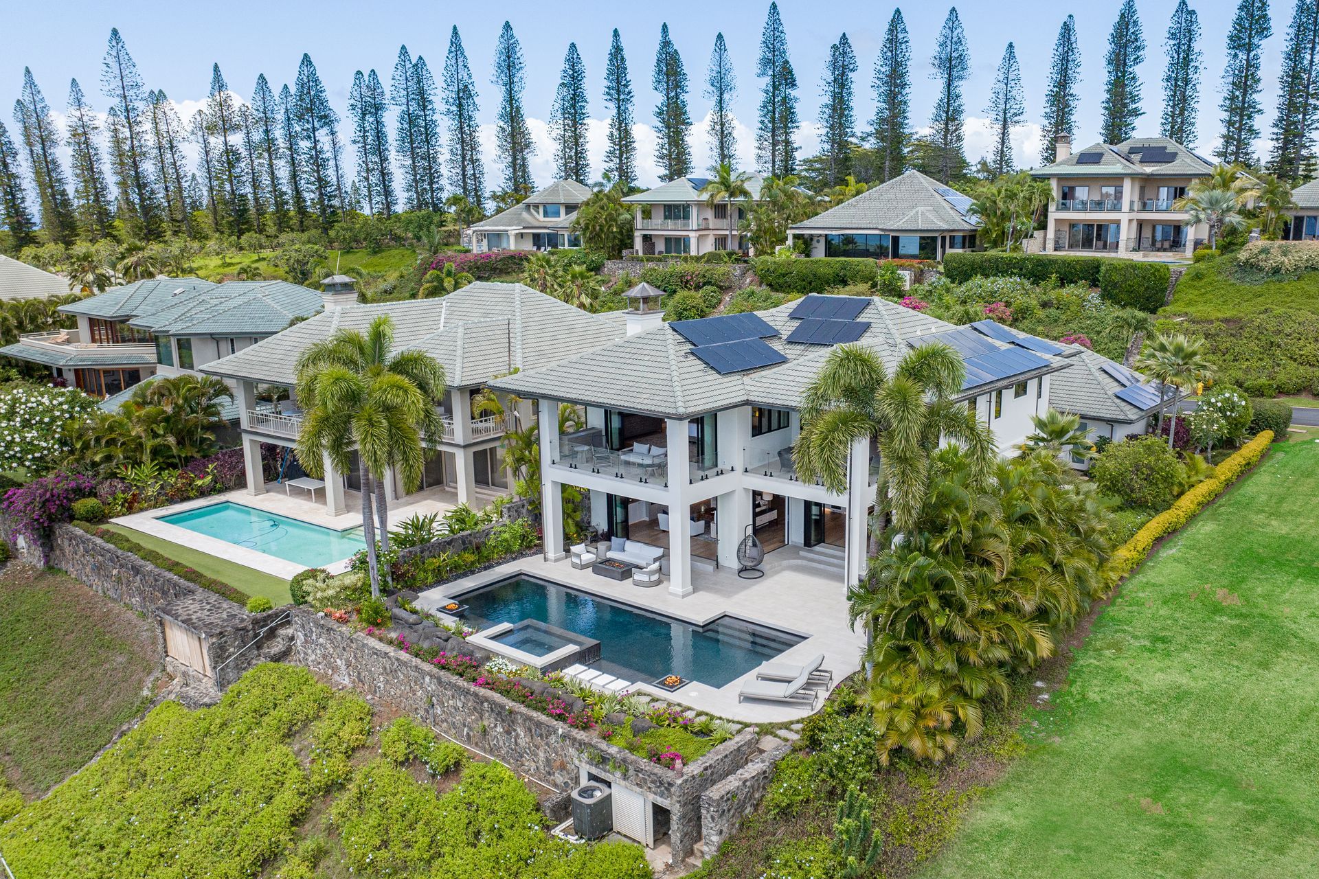 A beach with a building in the background and rocks in the foreground