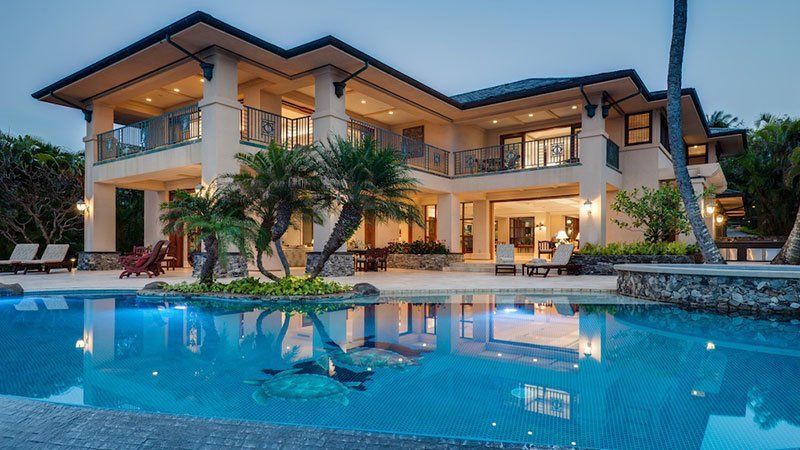 A large house with a swimming pool in front of it.