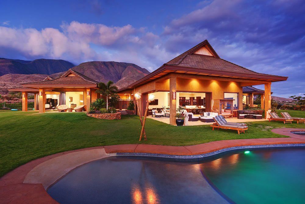 A large house with a swimming pool in front of it