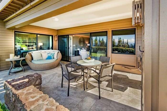 A patio with a table and chairs in front of a house.