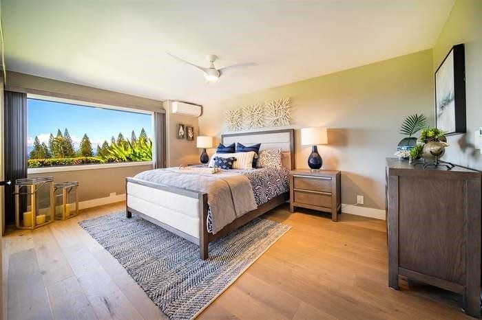 A bedroom with a large bed and a large window.