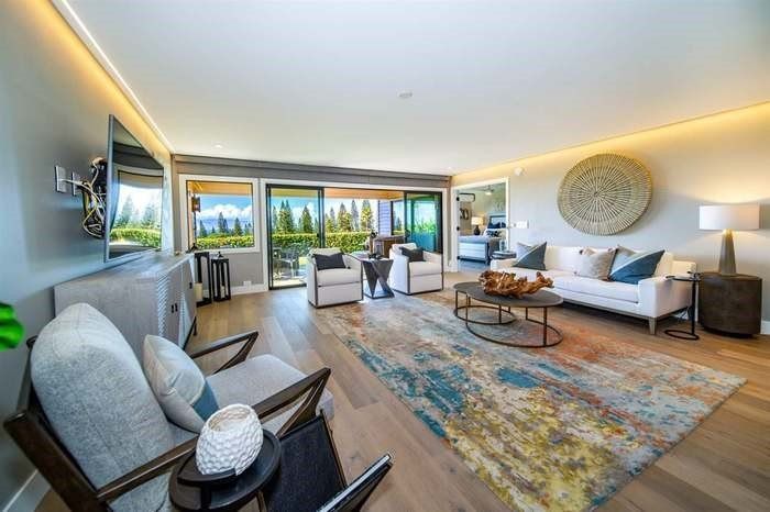 A living room with a couch , chairs , and a rug.