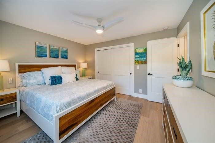 A bedroom with a king size bed and a ceiling fan.