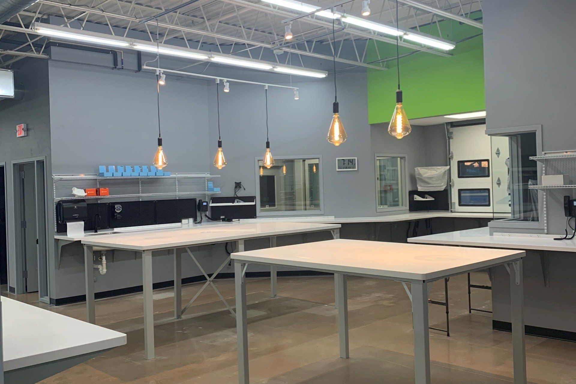 A large room with lots of tables and lights hanging from the ceiling.