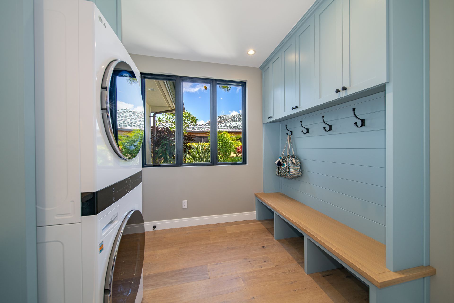 A laundry room with a washer and dryer and a bench.