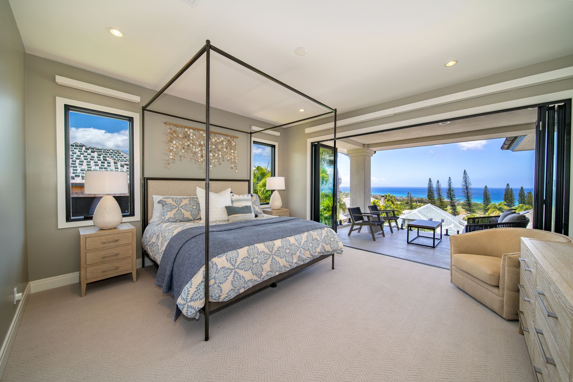 A bedroom with a canopy bed and a view of the ocean.