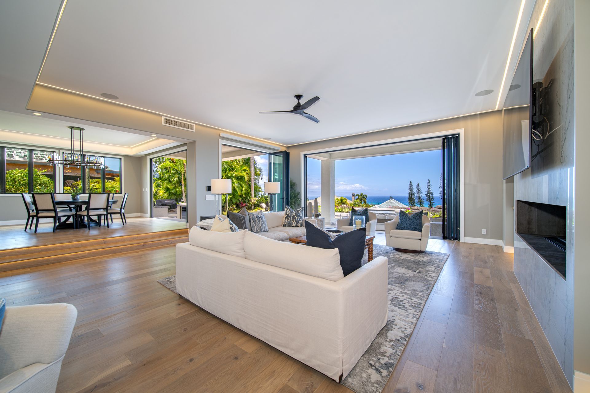 A living room with a couch , chairs , and a ceiling fan.