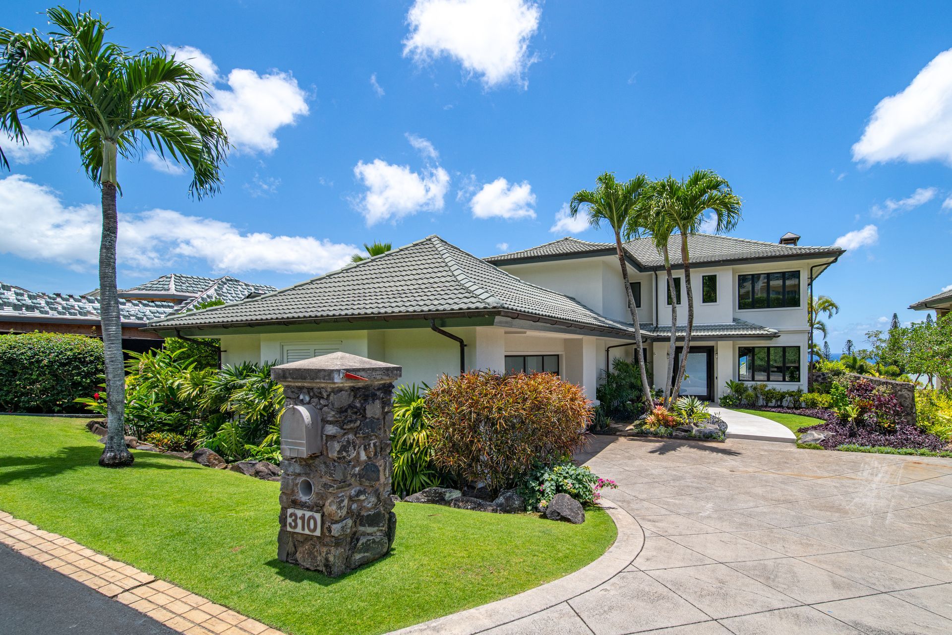 A large white house with palm trees in front of it