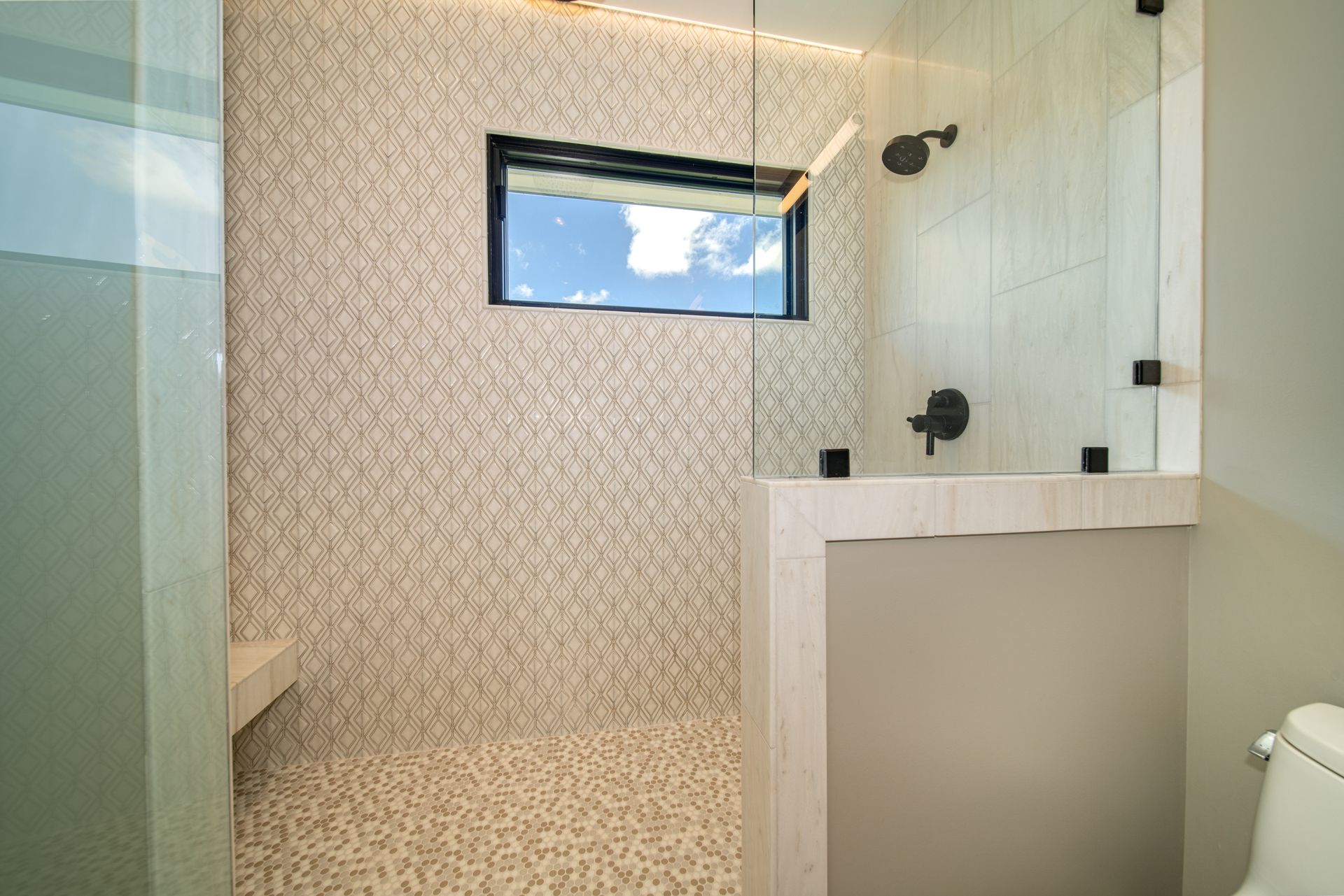 A bathroom with a walk in shower and a toilet.