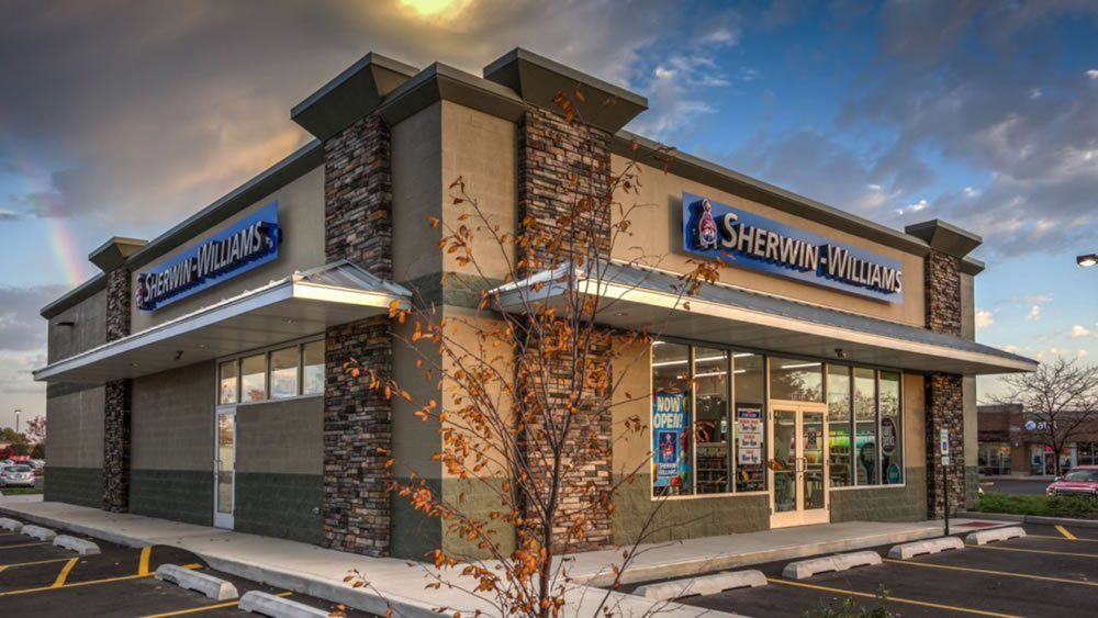 A sherwin williams store is located in a parking lot.