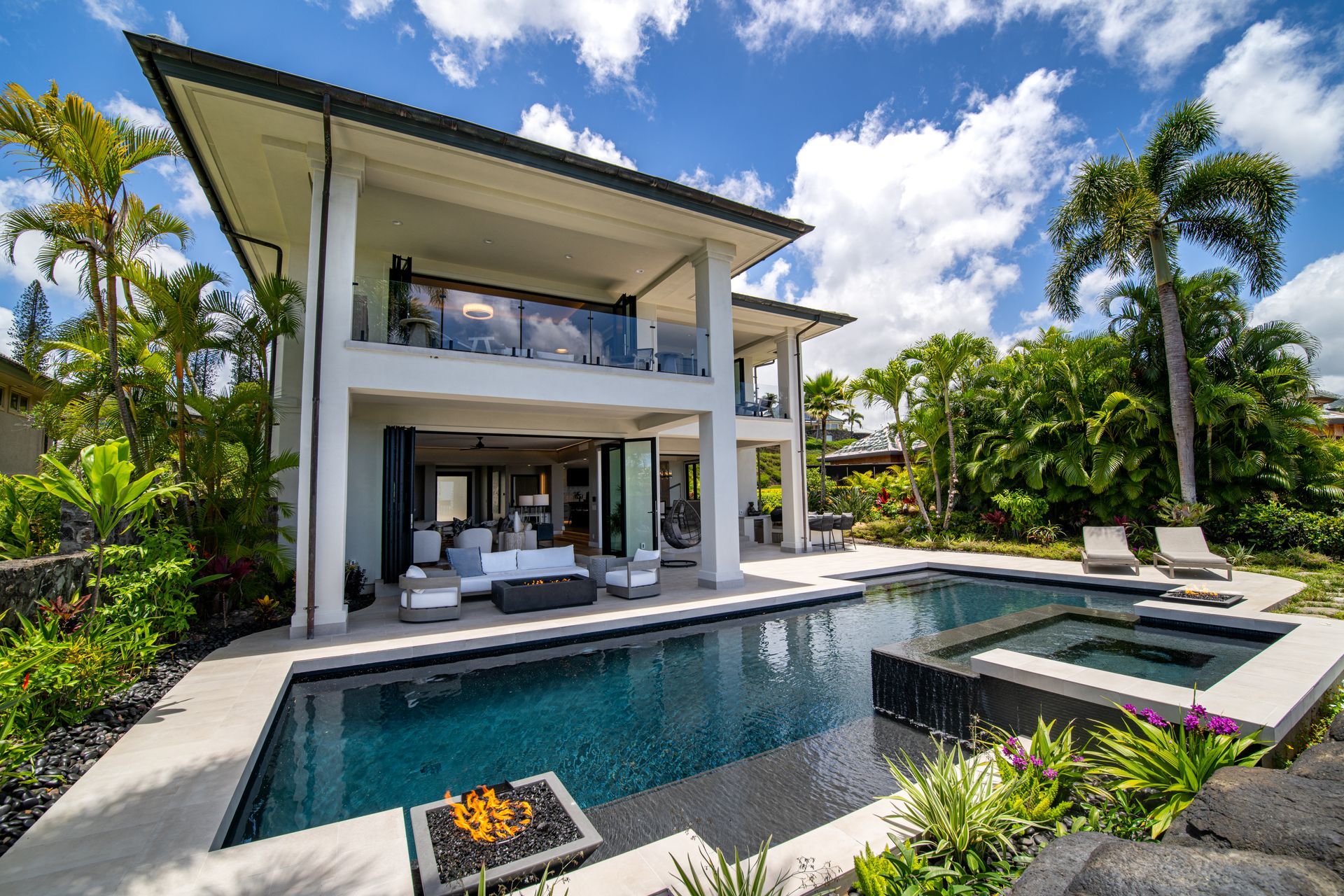 A large white house with a large swimming pool in front of it.