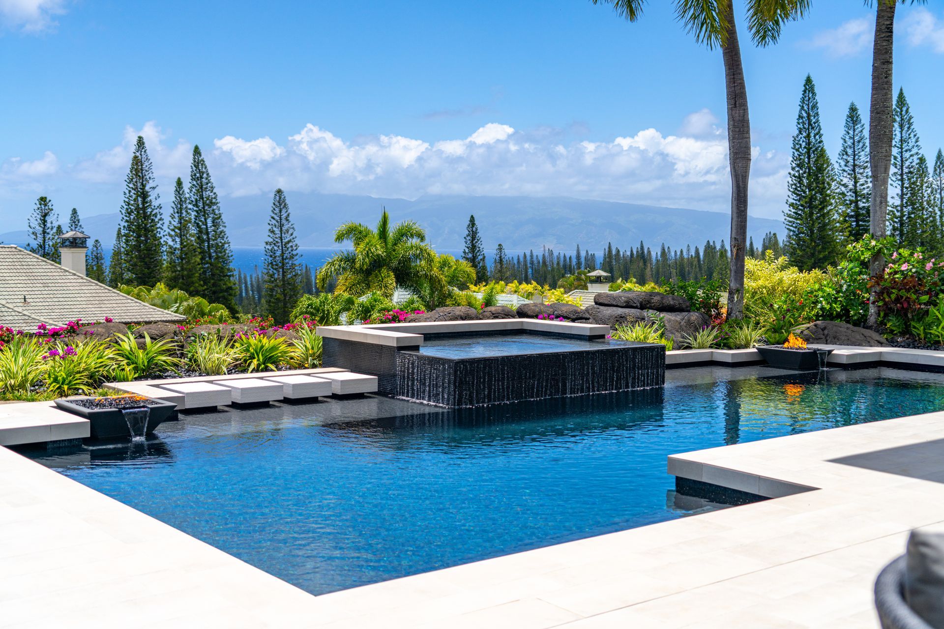 A large swimming pool with a view of the ocean and mountains.