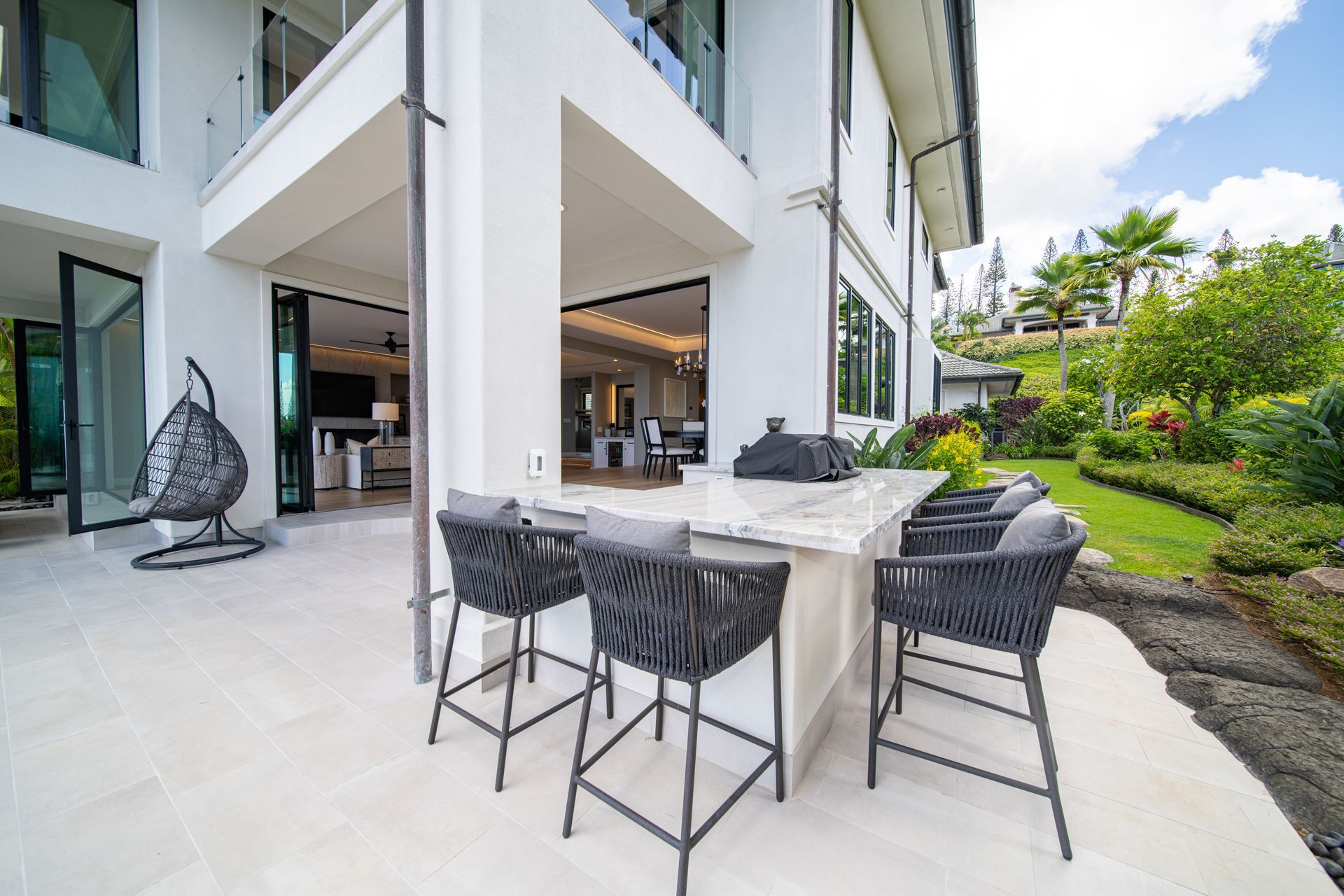 A large white house with a patio area with a table and chairs.