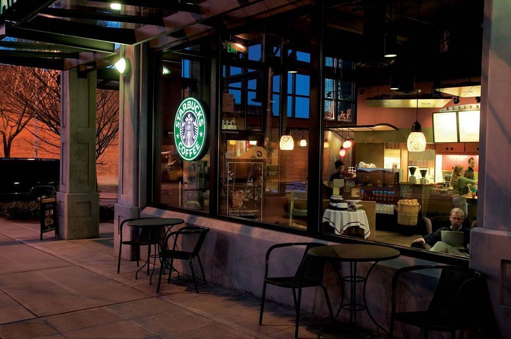 A starbucks coffee shop with tables and chairs outside