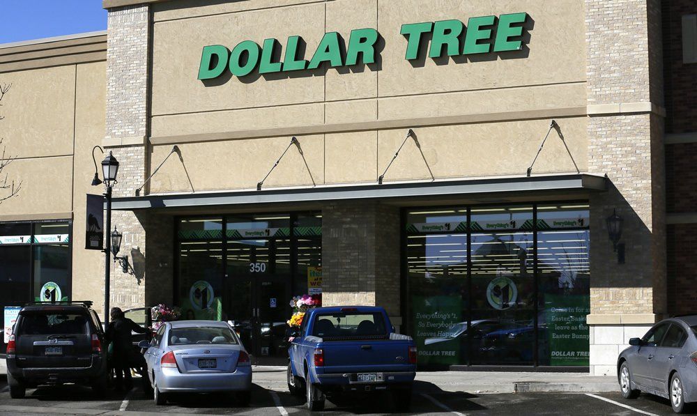 A dollar tree store with cars parked in front of it