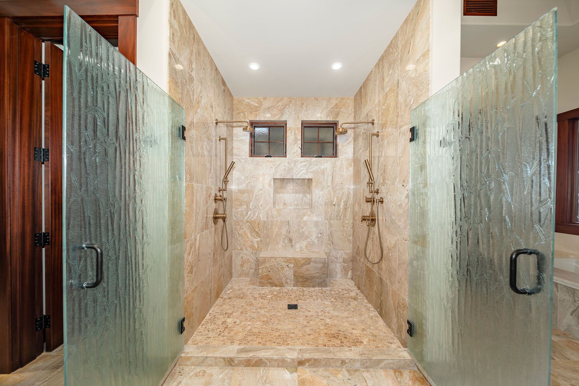 A bathroom with a walk in shower and two glass doors