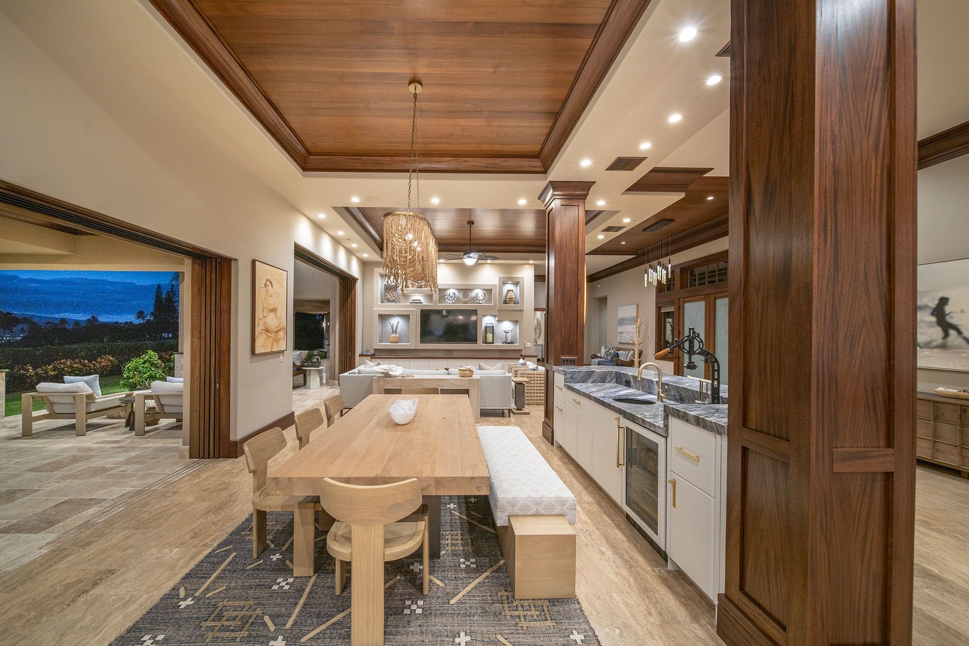 A large dining room with a wooden table and chairs and a kitchen