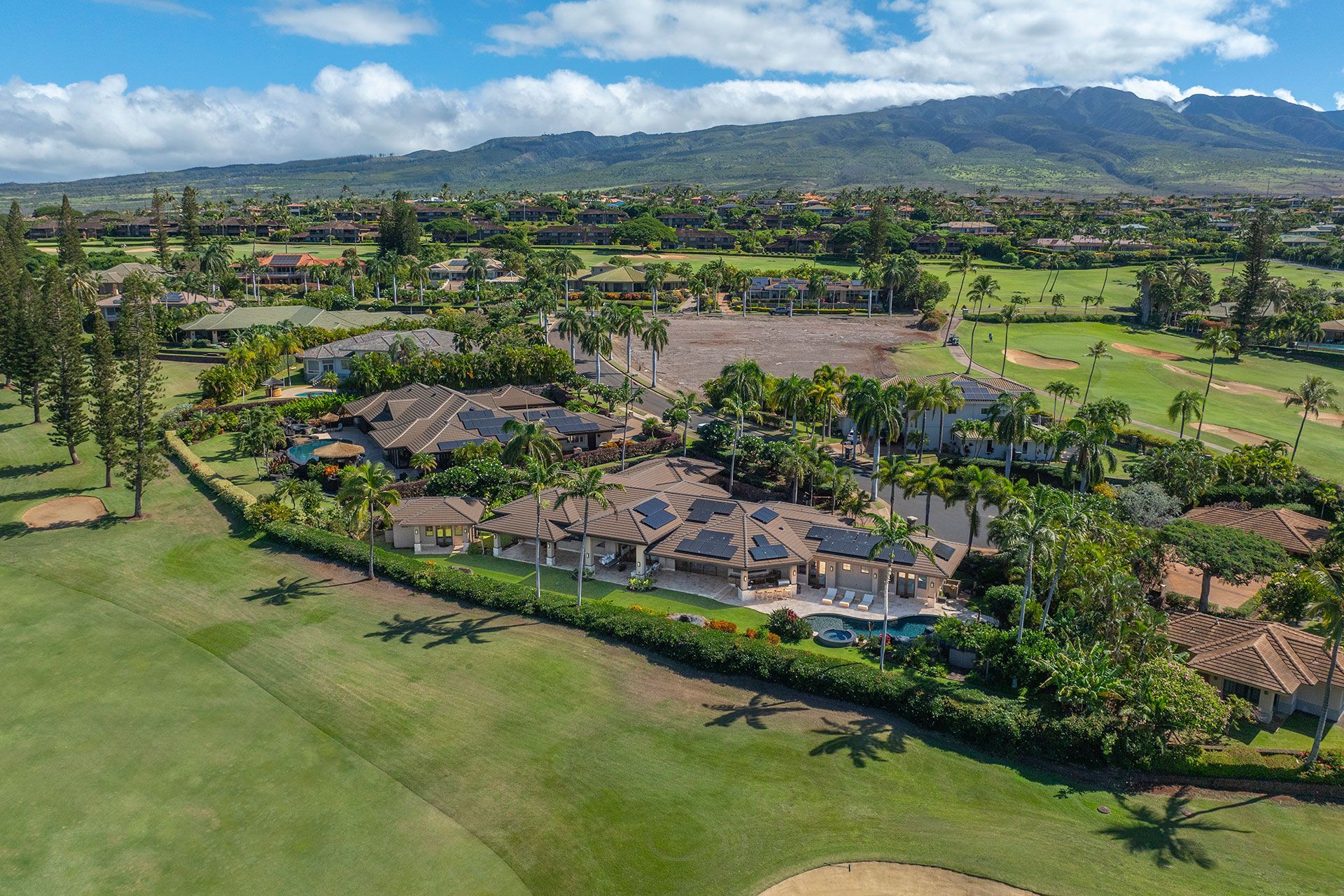 An aerial view of a golf course with mountains in the background