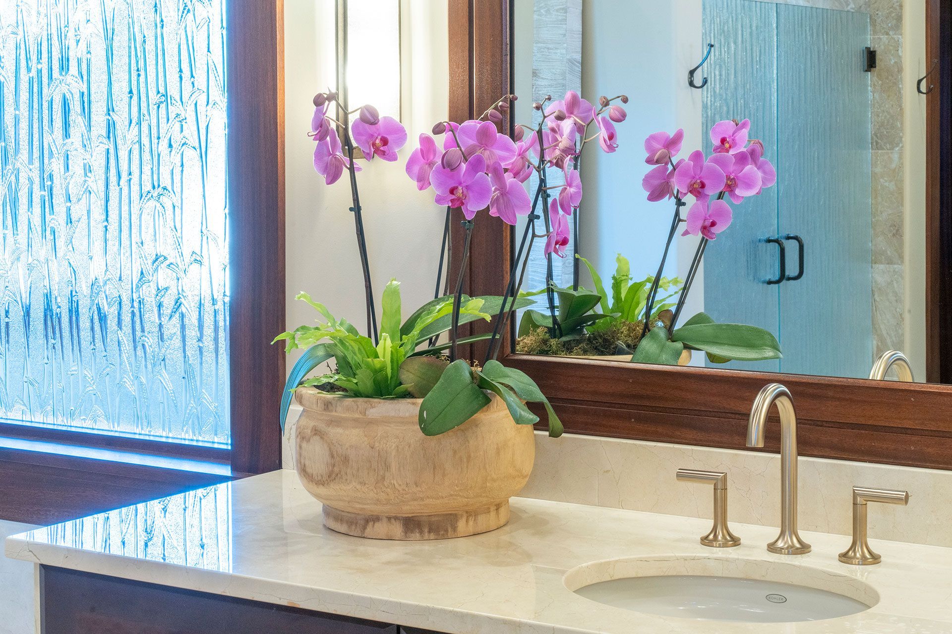 A bathroom sink with a vase of flowers on it