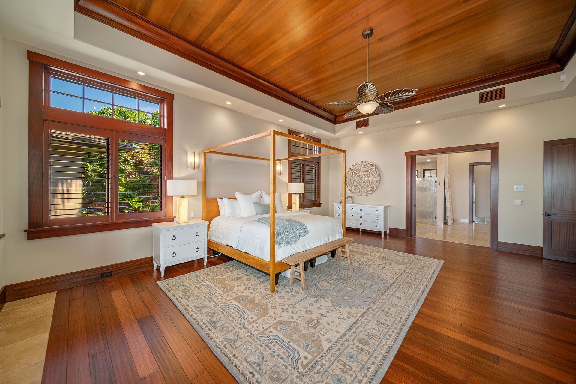 A bedroom with a canopy bed and a ceiling fan