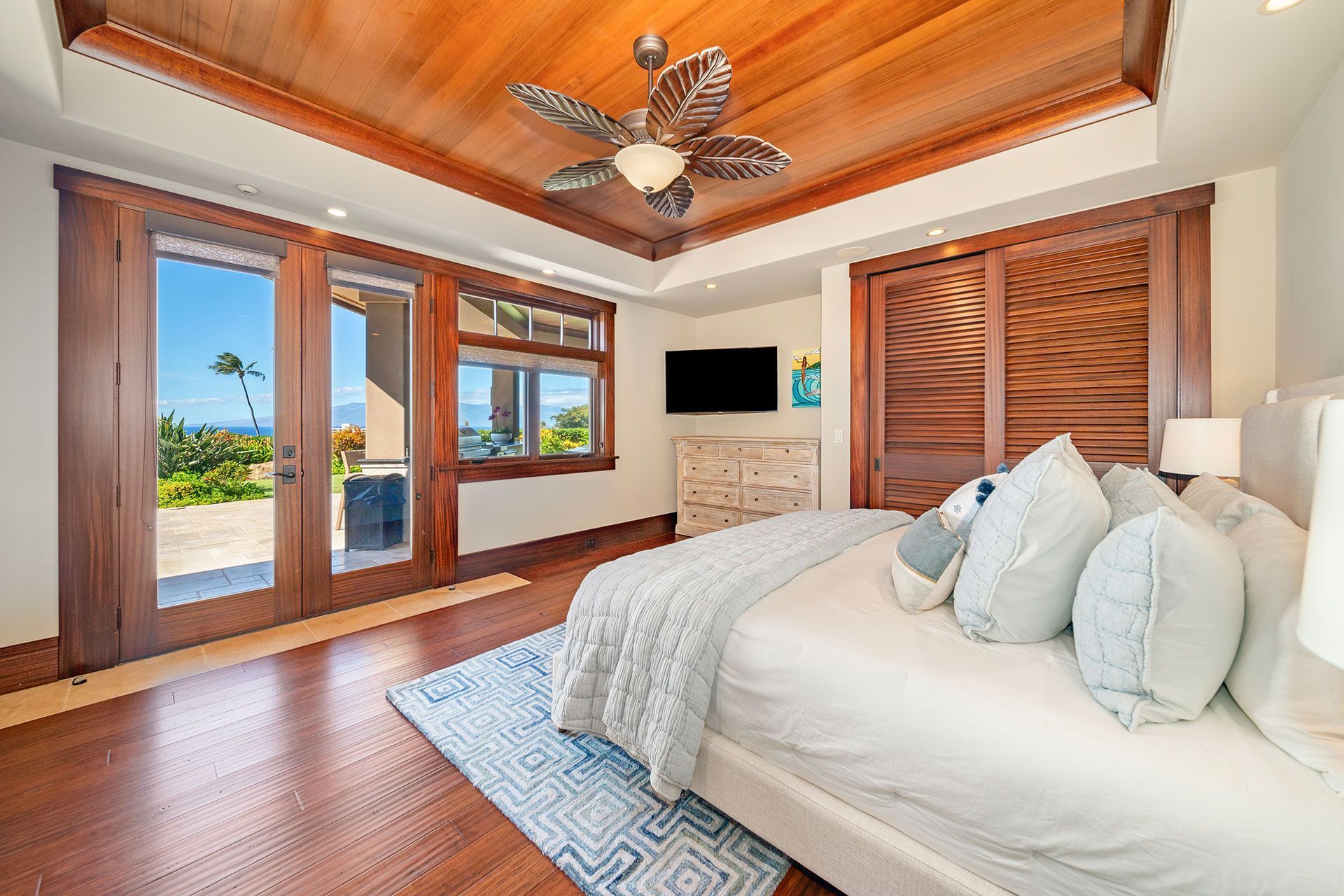 A bedroom with a large bed and a ceiling fan