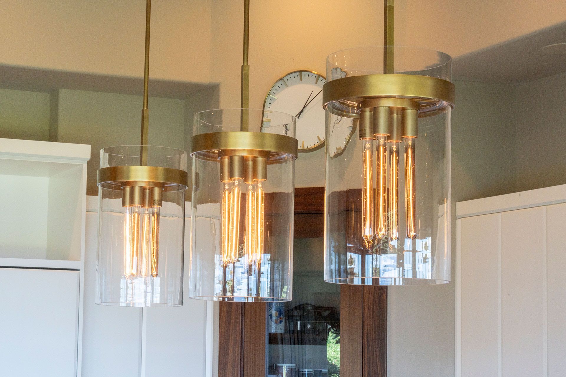 Three pendant lights are hanging from the ceiling in a kitchen