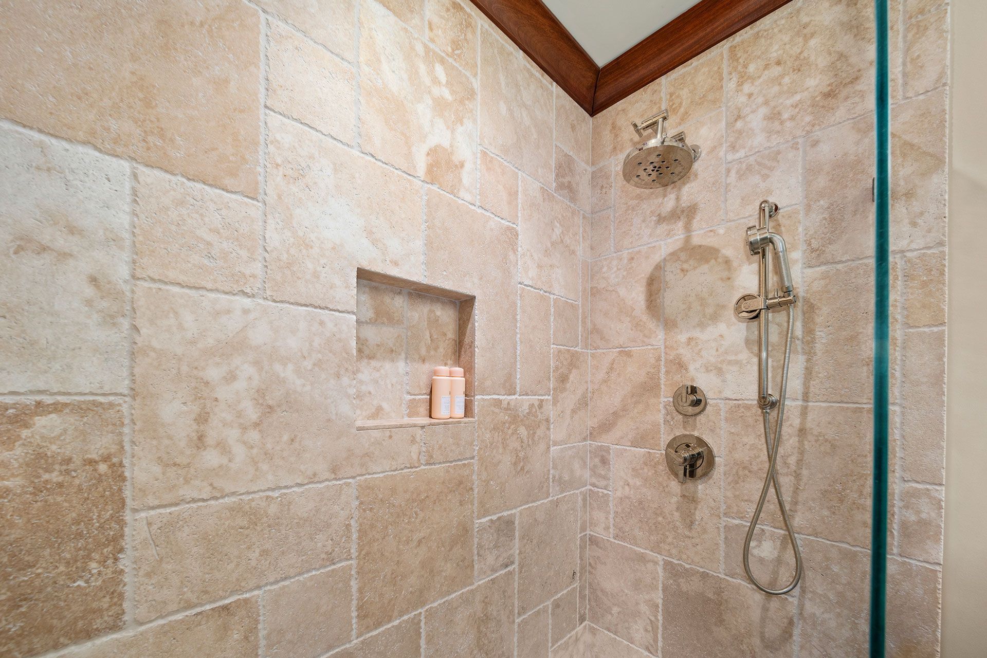 A shower with tiled walls and a glass door