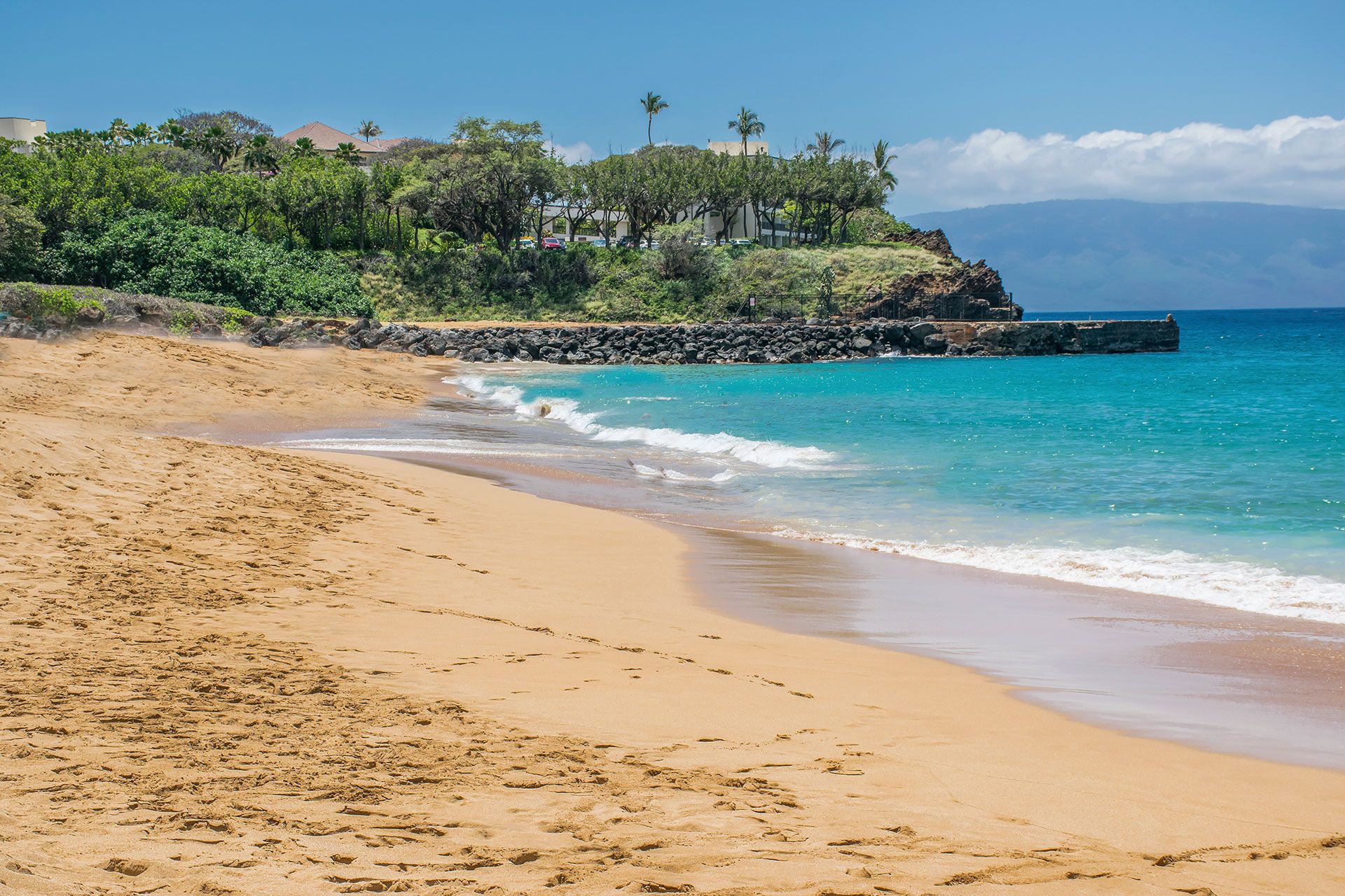 A beach with a lot of sand and waves coming in