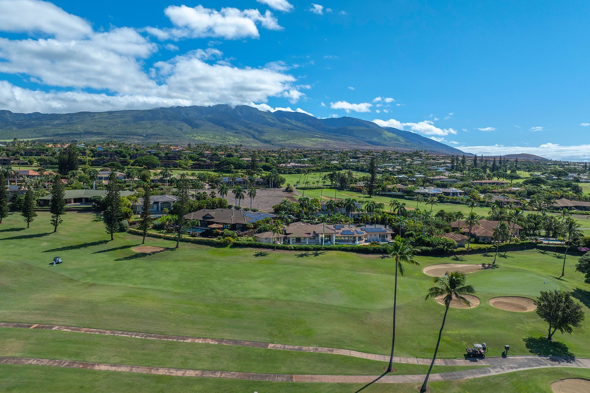 An aerial view of a golf course with mountains in the background