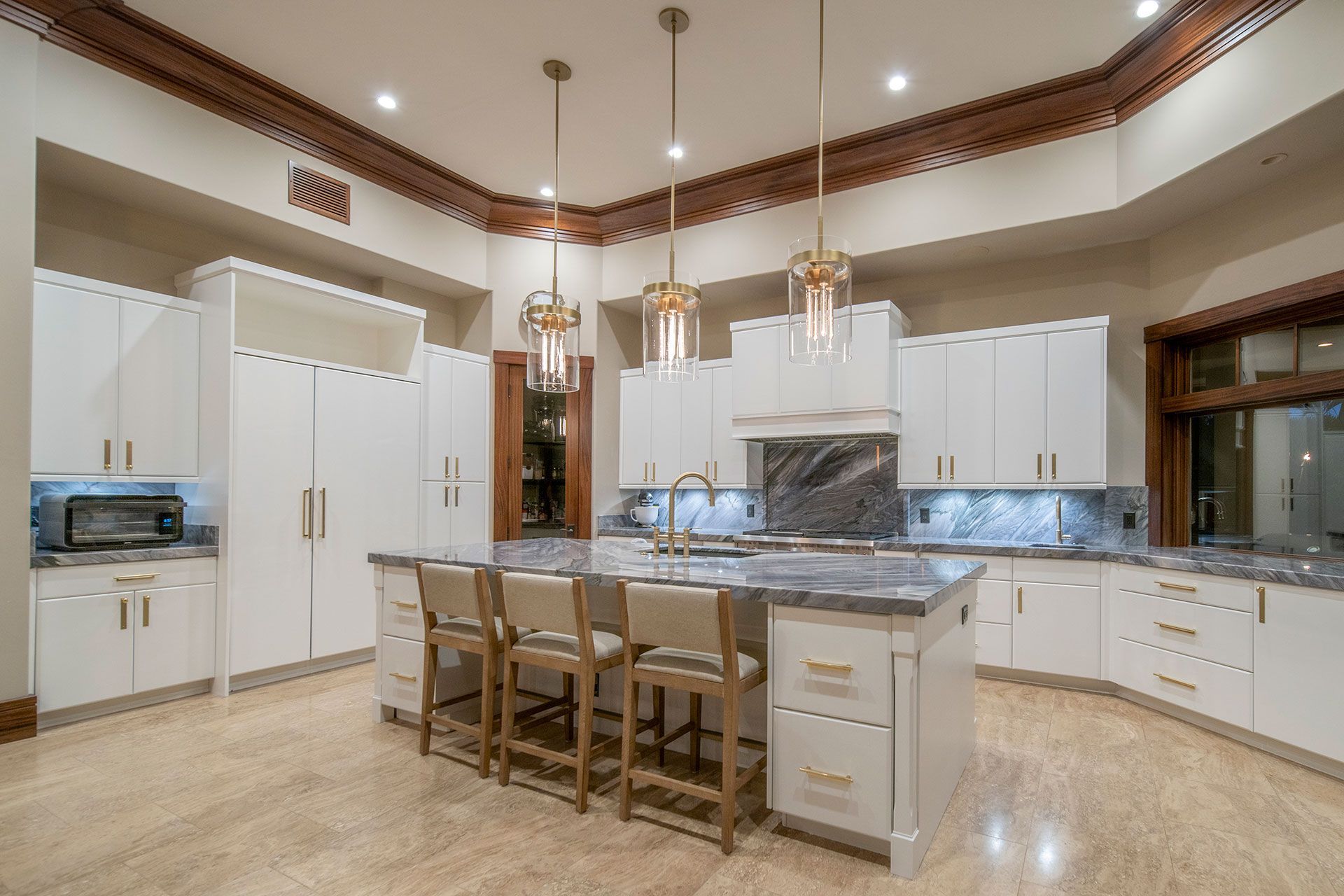 A large kitchen with white cabinets and a large island in the middle