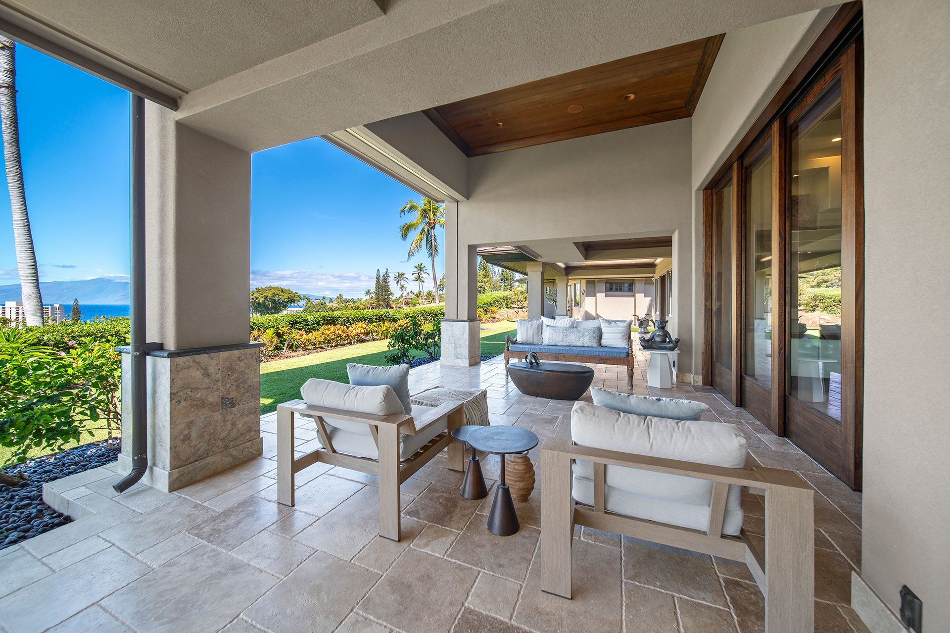 A patio with chairs and tables and a view of the ocean