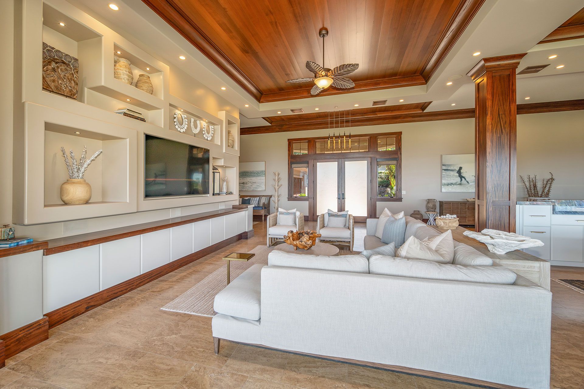 A living room with a couch, television, and ceiling fan.