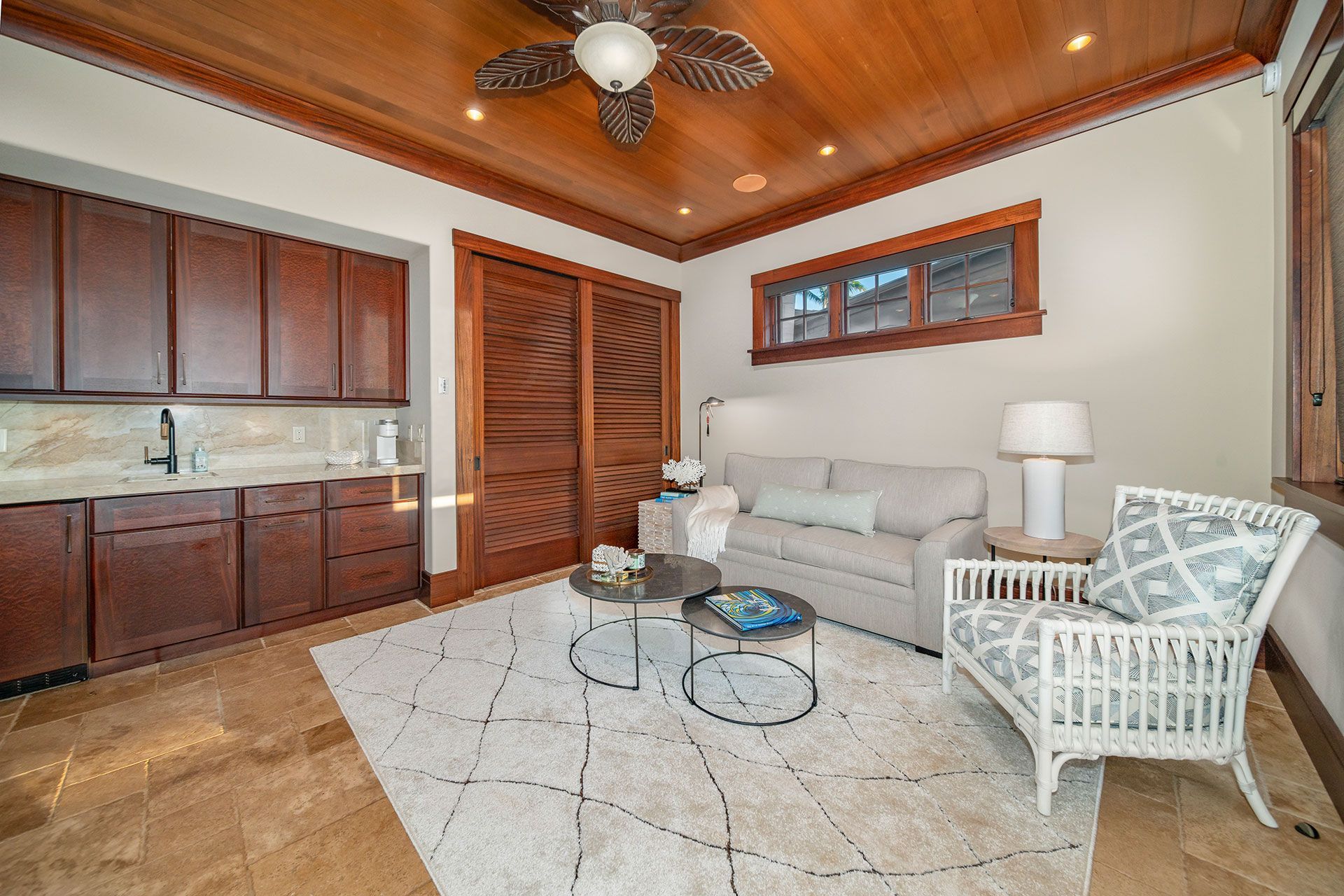 A living room with a couch, chair, coffee table and ceiling fan