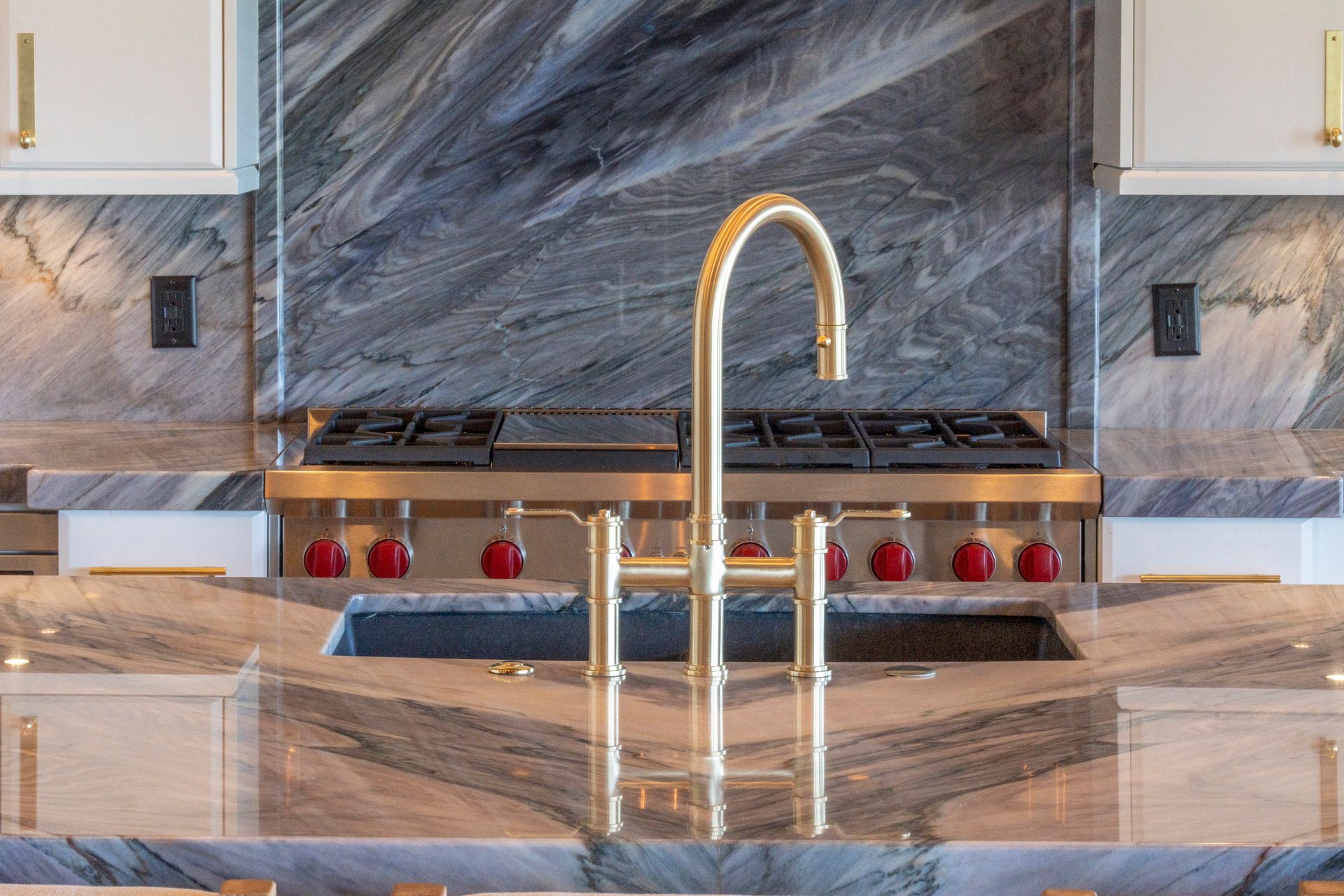 A kitchen with a sink , stove , and faucet.