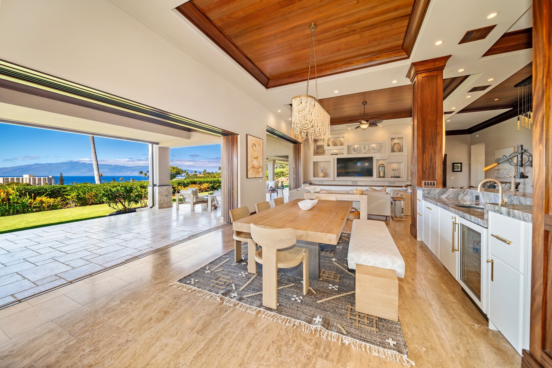 A dining room with a table and chairs and a view of the ocean.